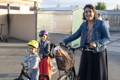une femme et deux enfants, les trois marchent à côté de leurs vélos et sourient à l'objectif - Agrandir l'image 73 sur 80, fenêtre modale
