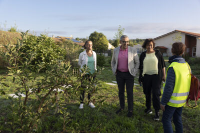quatre personnes dont le Maire et des élus échangent à l'extérieur, sur la verdure - Agrandir l'image 78 sur 80, fenêtre modale