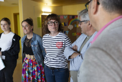 trois femmes et deux hommes discutent dans un hall jaune - Agrandir l'image 79 sur 80, fenêtre modale