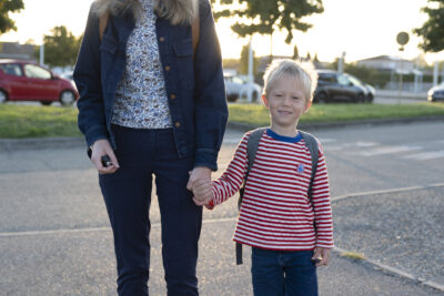 une femme et son fils qu'elle tient par la main, sur le trottoir, ils posent et sourient à l'objectif - Agrandir l'image 68 sur 80, fenêtre modale
