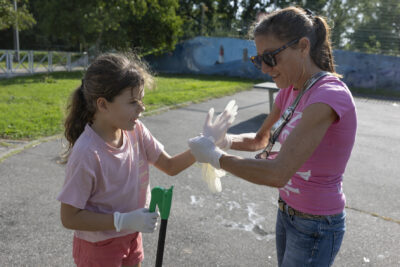 photo paysage d'une femme et d'une jeune fille, toutes deux habillées en rose, la femme met un gant blanc à la jeune fille - Agrandir l'image 8 sur 16, fenêtre modale