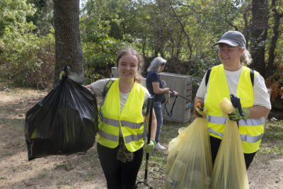 photo portrait de deux femmes en gilets jaunes qui portent des sacs poubelles et sourient à l'objectif - Agrandir l'image 10 sur 16, fenêtre modale