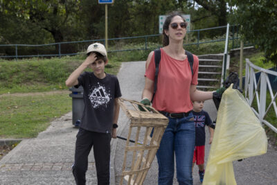 photo d'une femme et d'un jeune garçon, la femme tient des sacs poubelle et une cagette en bois cassé - Agrandir l'image 12 sur 16, fenêtre modale