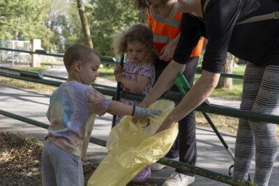 Photo portrait de deux femmes et deux enfants, une femme tient un sac poubelle jaune et un petit garçon dépose des déchets dedans - Agrandir l'image 3 sur 16, fenêtre modale