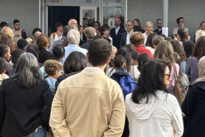 Photo derrière les familles rassemblées qu'on voit de dos, écouter le directeur faire un discours - Agrandir l'image 27 sur 80, fenêtre modale