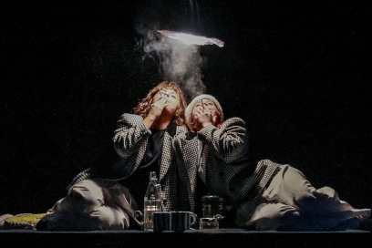 sous le halo d'une suspension lumineuse, deux femmes en tailleurs gris fument avec délectation visages levés dans la lumière - Agrandir l'image, fenêtre modale