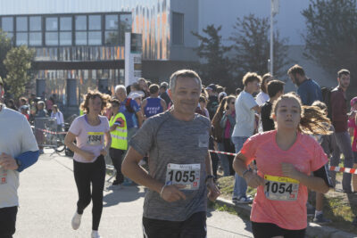 plusieurs personnes courent sur le parking de Quéfets, un homme sourit à l'objectif - Agrandir l'image 8 sur 23, fenêtre modale