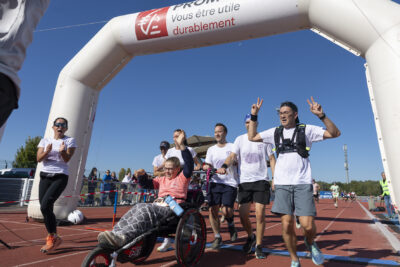 6 personnes viennent de franchir la ligne d'arrivée, devant une personne en fauteuil roulant à trois roues - Agrandir l'image 14 sur 23, fenêtre modale