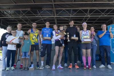 podium avec une dizaine de personnes qui tiennent médaille et coupe, avec leurs enfants sur scène - Agrandir l'image 21 sur 23, fenêtre modale