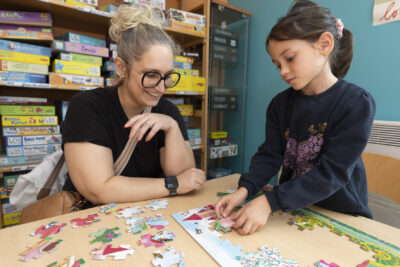 photo d'une femme et d'une jeune fille qui font un puzzle à une table - Agrandir l'image 9 sur 19, fenêtre modale