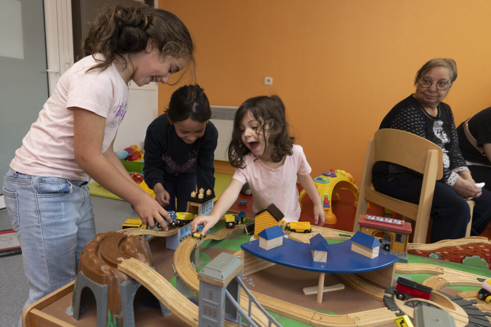 Photo paysage de trois petites filles qui jouent à un jeu de voiture en bois