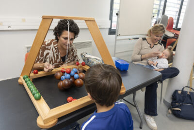 photo d'une femme et d'un petit garçon qui jouent à un jeu en bois sur une table - Agrandir l'image 16 sur 19, fenêtre modale