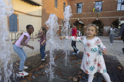 photo d'enfants qui jouent avec les jets d'eau sur le parvis de la mairie - Agrandir l'image 15 sur 20, fenêtre modale
