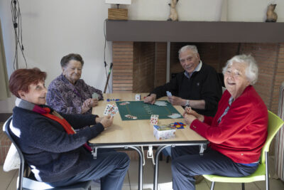 Quatre personnes âgées jouent aux cartes à une table, ils sourient à l'objectif - Agrandir l'image 5 sur 20, fenêtre modale