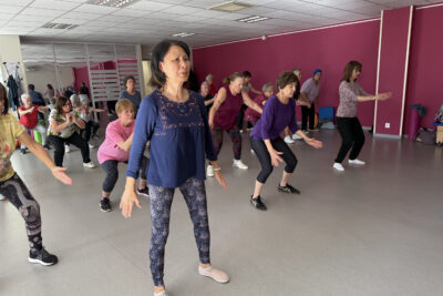 photo d'un cours de gym dans une salle, une vingtaine de personnes en pleine activité - Agrandir l'image 1 sur 3, fenêtre modale