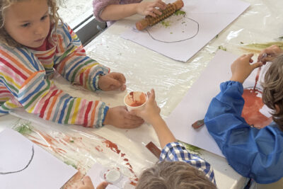 photo prise de haut de quatre enfants en train de peindre sur des feuilles blanches à l'aide d'outils comme un rouleau en bois - Agrandir l'image 10 sur 10, fenêtre modale
