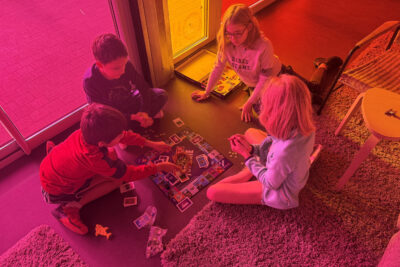 quatre enfants sont par terre en train de jouer à un jeu de plateau monopoly fortnite - Agrandir l'image 3 sur 8, fenêtre modale