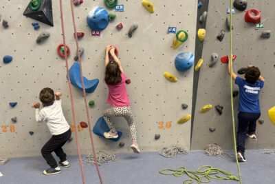 photo de trois enfants qui tiennent des prises en bas d'un mur d'escalade - Agrandir l'image 6 sur 9, fenêtre modale