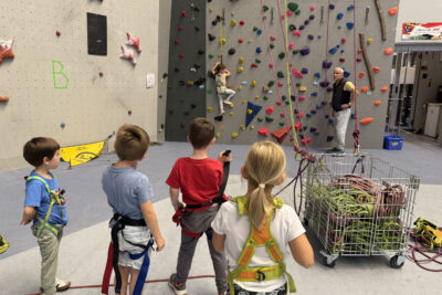 photo d'un groupe de quatre enfants qui regardent un autre enfant en train de grimper au mur, sous le regard d'un moniteur - Agrandir l'image 5 sur 9, fenêtre modale