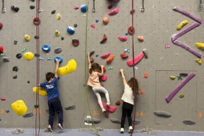 photo de trois enfants en bas d'un mur d'escalade qui tiennent des prises - Agrandir l'image 4 sur 9, fenêtre modale