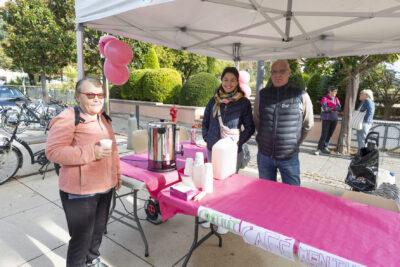 photo de la buvette avec un distributeur de café, deux personnes derrière le stand, une femme prend un café et sourit à l'objectif - Agrandir l'image 17 sur 21, fenêtre modale