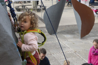 photo d'un petit enfant qui monte au mur d'escalade sur le parvis de la mairie - Agrandir l'image 21 sur 21, fenêtre modale