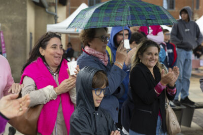 photo de trois femmes et un petit garçon, qui applaudissent, une tient un parapluie, une autre un gobelet - Agrandir l'image 8 sur 21, fenêtre modale