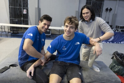 photo d'un grimpeur assis sur une table, deux autres lui tiennent les bras - Agrandir l'image 63 sur 68, fenêtre modale