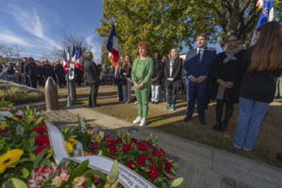 photo d'une femme habillée tout en vert qui se recueille devant le monument aux morts - Agrandir l'image 13 sur 38, fenêtre modale