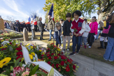 photo de trois jeunes garçons qui déposent une rose devant le monument aux morts - Agrandir l'image 16 sur 38, fenêtre modale