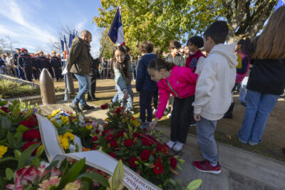 photo de deux jeunes filles qui déposent une rose devant le monument aux morts - Agrandir l'image 17 sur 38, fenêtre modale