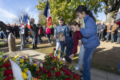 photo de quatre jeunes ados qui déposent des roses devant le monument aux morts - Agrandir l'image 18 sur 38, fenêtre modale