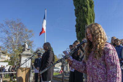 photo de plusieurs jeunes femmes en train de faire un discours, on voit le drapeau français à l'arrière plan - Agrandir l'image 30 sur 38, fenêtre modale