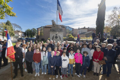 photo de groupe avec les enfants au premier plan, tout le monde est rassemblé devant le monument aux morts - Agrandir l'image 12 sur 38, fenêtre modale