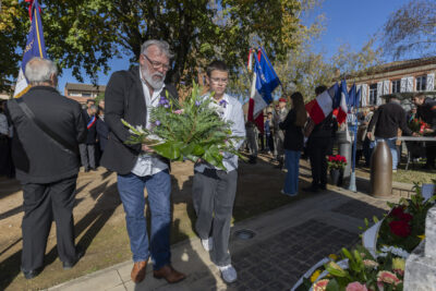 photo d'un homme et d'un jeune homme qui s'apprêtent à déposer une gerbe devant le monument aux morts - Agrandir l'image 9 sur 38, fenêtre modale