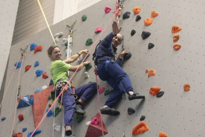 photo de deux personnes qui grimpent au mur d'escalade et font signe à l'objectif - Agrandir l'image 3 sur 68, fenêtre modale