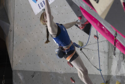 photo d'une grimpeuse qui saute depuis une prise jaune pour en atteindre une autre - Agrandir l'image 21 sur 68, fenêtre modale