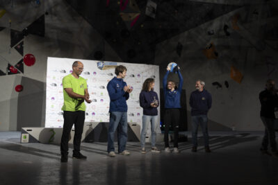 photo de cinq personnes devant le mur et une bâche avec les sponsors de l'événement, une porte au-dessus de sa tête sa coupe - Agrandir l'image 31 sur 68, fenêtre modale
