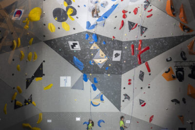photo du mur d'escalade vu depuis le public, à la verticale, on voit des athlètes en train de grimper - Agrandir l'image 34 sur 68, fenêtre modale