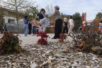 photo d'un atelier self défense, prise au ras du sol avec vue sur les feuilles aux couleurs d'automne, on voit des binômes s'entraîner, avec une personne qui donne un coup de genou et une autre qui se protège - Agrandir l'image 22 sur 32, fenêtre modale