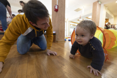 photo d'un enfant avec un adulte, l'enfant sort d'un tunnel à quatre pattes et l'homme adulte le regarde en souriant, à quatre pattes lui aussi - Agrandir l'image 5 sur 32, fenêtre modale