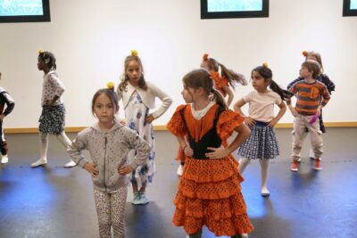 photos d'une dizaine de jeunes filles dans une salle de danse avec un jeune garçon également, qui se tiennent debout les mains sur les hanches - Agrandir l'image 5 sur 7, fenêtre modale