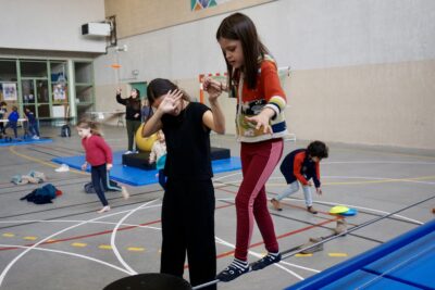 une jeune fille marche sur une corde suspendue aidée par une animatrice - Agrandir l'image 1 sur 16, fenêtre modale