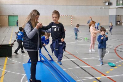 photo d'un jeune garçon qui marche en équilibre sur un fil à l'aide d'une femme qui l'accompagne en le tenant par la main - Agrandir l'image 5 sur 16, fenêtre modale