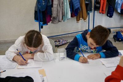 deux enfants, une jeune fille et un jeune garçon, assis à table en train de dessiner sur une feuille blanche - Agrandir l'image 1 sur 10, fenêtre modale