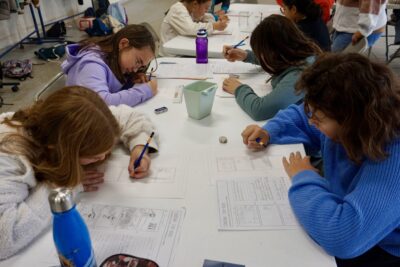 quatre enfants assis à une table occupés à dessiner dans des cases - Agrandir l'image 10 sur 10, fenêtre modale