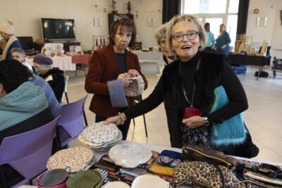 photo de femmes qui regardent des objets en vente sur un stand en souriant - Agrandir l'image 24 sur 26, fenêtre modale