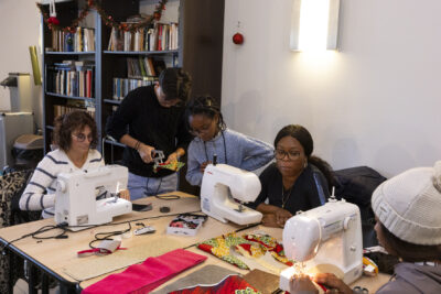 photo de femmes et d'une jeune fille qui travaillent du tissu avec des machines à coudre - Agrandir l'image 26 sur 26, fenêtre modale