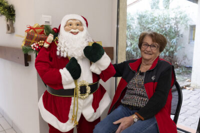 photo d'une femme assise à côté d'une statue de père noël, elle pose avec en souriant - Agrandir l'image 15 sur 26, fenêtre modale