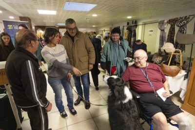 photo d'un groupe de personnes, dont le Maire qui échange et regardent un chien noir et blanc en laisse - Agrandir l'image 18 sur 26, fenêtre modale
